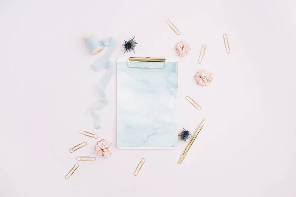 Klembord, rose toppen, blauwe lint, gouden pen en clips — Stockfoto