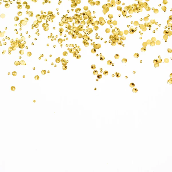 Oropel de confeti dorado sobre fondo blanco — Foto de Stock