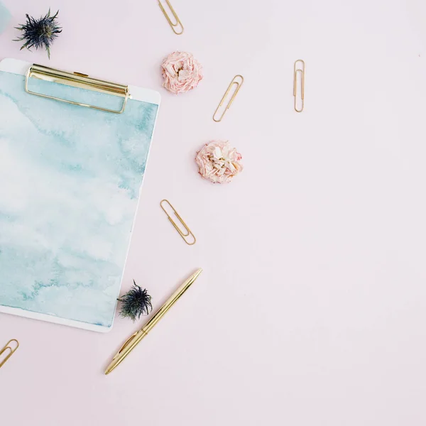 Prancheta, botões de rosa, fita azul, caneta dourada e clipes — Fotografia de Stock