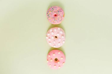 Yeşil arka planda pembe çörekler