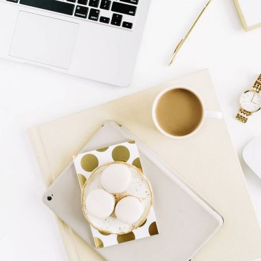 Laptop, tatlılar, kahve, kadınsı aksesuarları ile stilize kadınların çalışma alanı