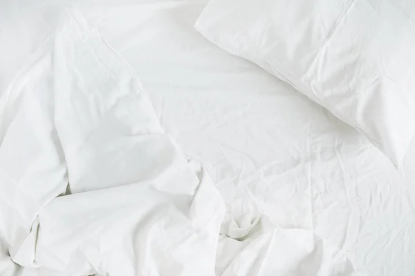 Bílá postel s polštářem, přikrývkou a list — Stock fotografie