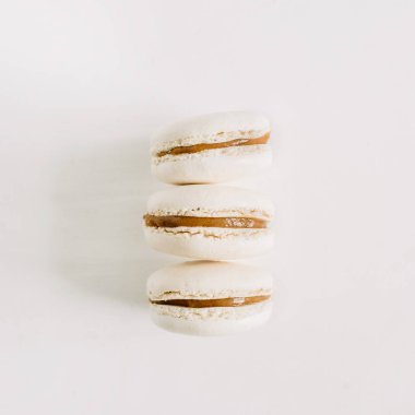 Beyaz üzerine üç pastel bej bademli kurabiye