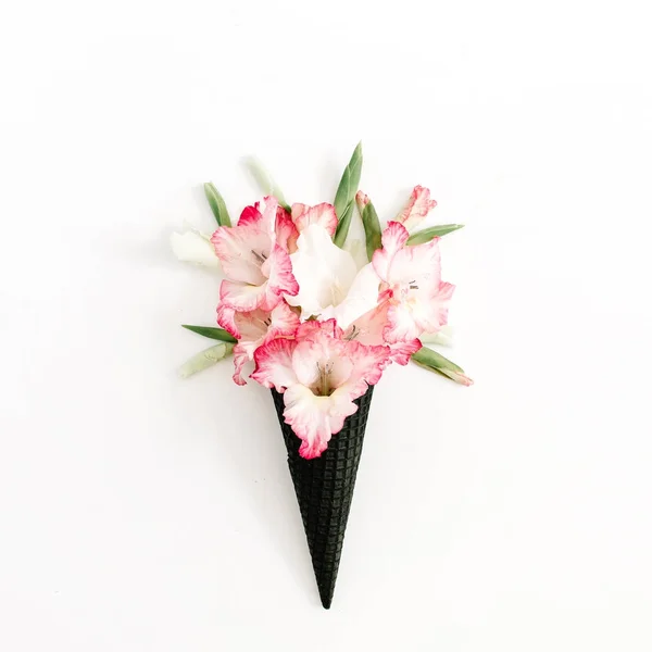 Black ice cream wafel kegel met roze gladiolen bloemen — Stockfoto