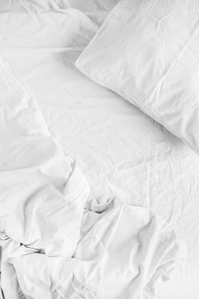 white bed with pillow, blanket and sheet