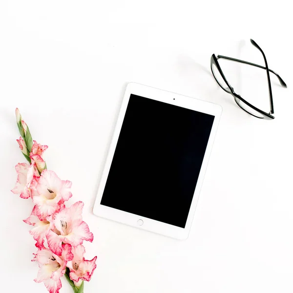 Tablet, gladiolus flower and glasses — Stock Photo, Image