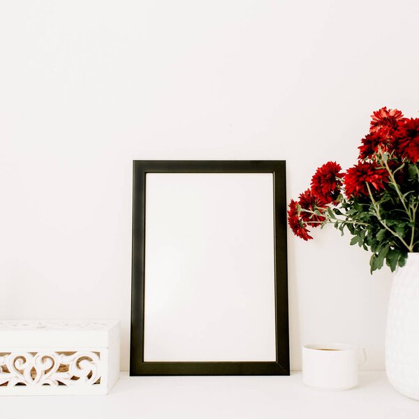 Photo frame and beautiful red flowers bouquet