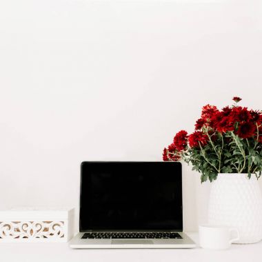 Ofis büro dizüstü bilgisayar ve güzel kırmızı çiçekler buket