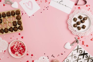Sevgililer günü, aşk kavramı. Yapılan konfeti, kalp sembol aksesuarları, tatlılar, kartpostallar pembe bir arka plan üzerinde çerçeve kadar alay et. Düz yatıyordu, en iyi görünümü.