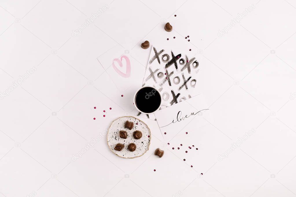Artistic concept with painted cards, coffee and sweets. Flat lay, top view Valentine's Day or Love composition.