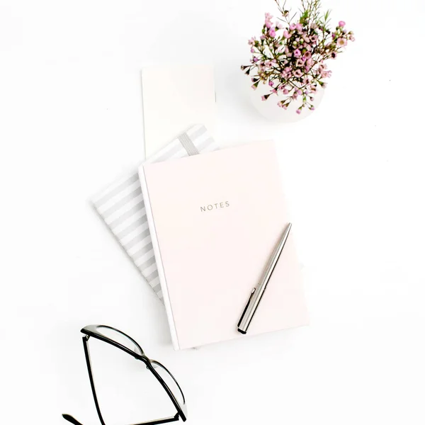 Kadın blog kompozisyon defter, gözlük, kalem ve kır çiçekleri beyaz arka plan üzerinde. Düz yatıyordu, en iyi görünümü.