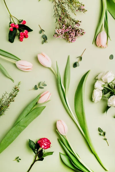 花のパターンはピンクのチューリップ 緑色の背景上のオトギリソウの花から成っています フラット横たわっていた トップ ビュー春花コンセプト — ストック写真