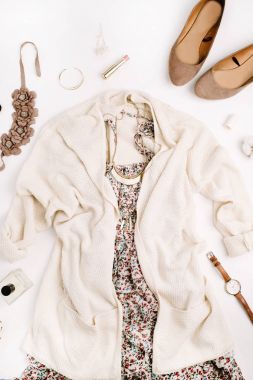 Düz yatıyordu moda bakmak kavramı. Bayan giyim ve aksesuarları: hırka, elbise, Ayakkabı, saat, parfüm, ruj, bilezik, kolye beyaz arka plan üzerinde. Üstten Görünüm.