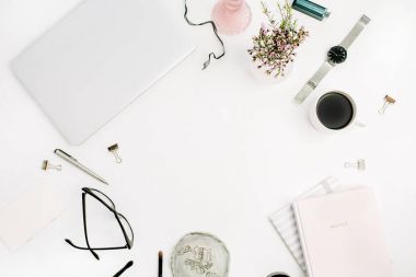 Pastel pembe notebook, dizüstü bilgisayar, gözlük, kahve fincanı, kır çiçekleri ve aksesuar beyaz masa üzerine çerçeve. Düz yatıyordu, en iyi görünümü mockup arka plan.