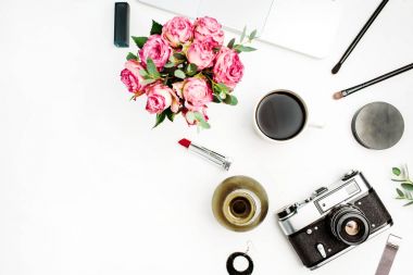 Kadınsı düz yatıyordu, gül çiçek buketi, vintage fotoğraf makinesi, kahve fincanı ve aksesuar beyaz arka plan üzerinde çalışma alanını üst göster. Kadınlar ev ofis kavramı.