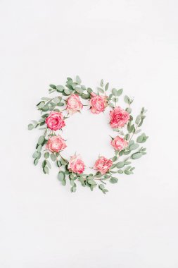 Kırmızı gül çiçekler ve beyaz arka plan üzerinde izole okaliptüs dalları çerçeve çiçek çelenk yaptı. Düz yatıyordu, en iyi görünümü gelin mockup.