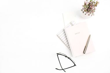 Kadın blog kompozisyon defter, gözlük, kalem ve kır çiçekleri beyaz arka plan üzerinde. Düz yatıyordu, en iyi görünümü.