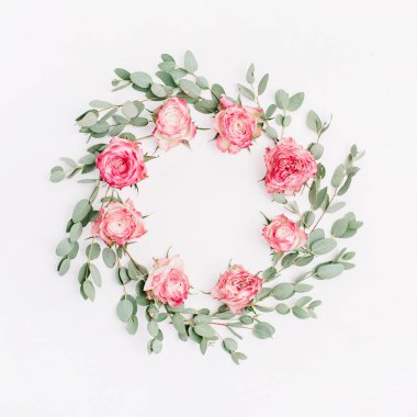 Kırmızı gül çiçekler ve okaliptüs dalları beyaz arka plan üzerinde çerçeve çiçek çelenk. Düz yatıyordu, en iyi görünümü çiçek mockup boş alan içeren.