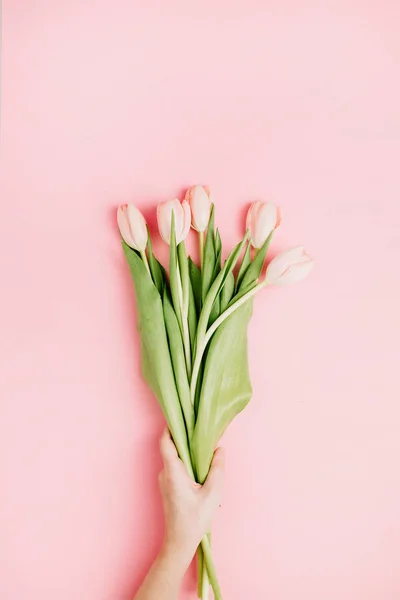 Frau Hand Halten Pastellrosa Tulpenblüten Strauß Auf Rosa Hintergrund Flache — Stockfoto