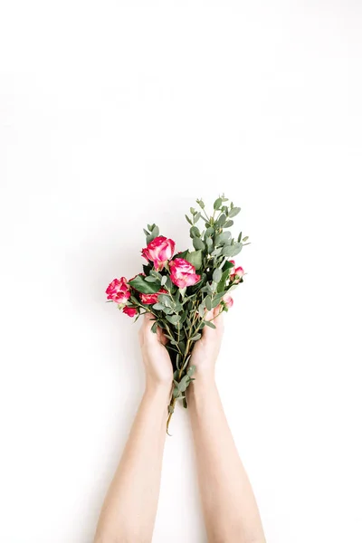 女子手捧玫瑰花和桉树枝花束在白色背景 顶部视图弹簧背景 — 图库照片