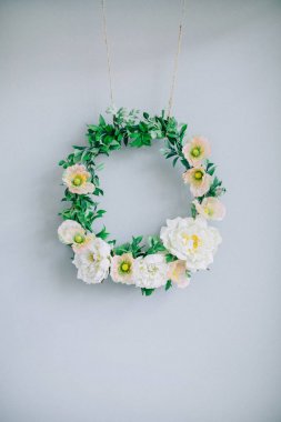 Soluk mavi duvarının yakınında çelenk çerçeve çiçek.