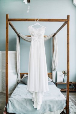 Güzel beyaz gelin gelinlik yatak önünde.