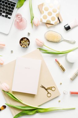 Kadın ev ofis Resepsiyon çalışma alanı dizüstü bilgisayar, Pembe Lale çiçek, notebook, Aksesuar ve kozmetik beyaz arka plan üzerinde. Düz yatıyordu, en iyi görünümü moda blog kompozisyon.
