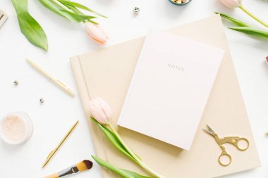 Kadınsı ev ofis Resepsiyon çalışma alanıyla defter, Pembe Lale çiçek ve aksesuarları beyaz arka plan üzerinde. Flatlay, üstten görünüm moda blog kompozisyon.