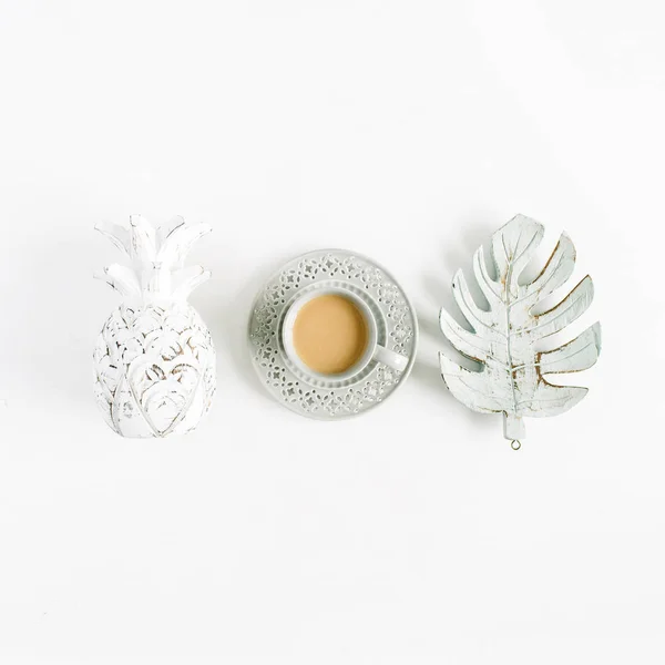 Decorations: pineapple, coffee, monstera palm leaf on white background. Flat lay, top view blog hero header.
