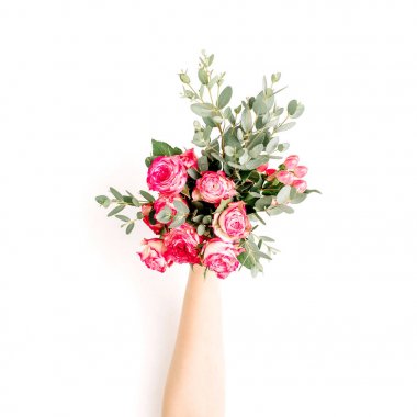 El Flatlay gül çiçek ve okaliptüs buket beyaz arka plan üzerinde tutun. Düz yatıyordu, en iyi görünümü bahar blog kahraman üstbilgi arka planı.