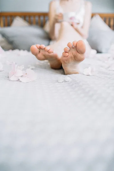 Ženské Nohy Pastelově Modrou Přikrývku Květinovými Lístky — Stock fotografie