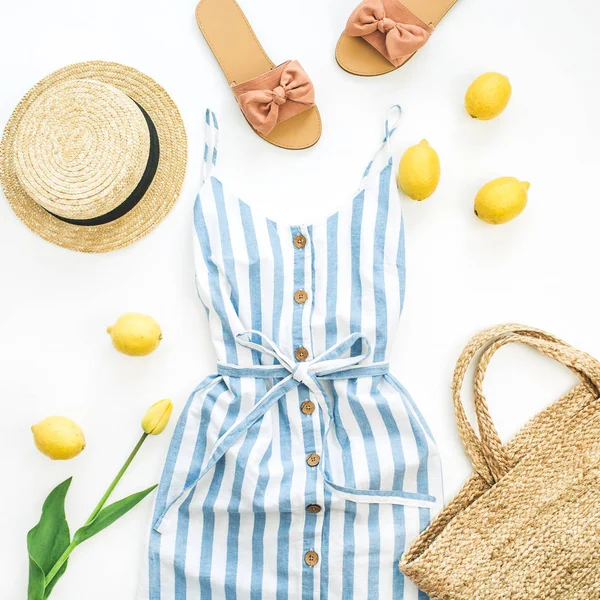 Yaz kadın moda şık kompozisyon. Giysi, terlik, saman, limon, Lale çiçek ve aksesuarları beyaz arka plan üzerinde. Düz yatıyordu, en iyi görünümü.