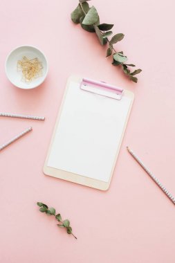 Düz yatıyordu office çalışma alanı boş pano ile okaliptüs, pembe arka plan dalları. Üstten Görünüm en az sahte Şablon kavram kadar.