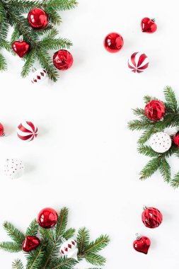 Noel / Yeni Yıl kompozisyonu. Çerçeveyi, köknar iğnesi dallarından, noel süslemelerinden ve beyaz arka plandaki süslemelerden oluşan boş fotokopi alanıyla düzenle. Düzlük, üst görünüm bayram konsepti.