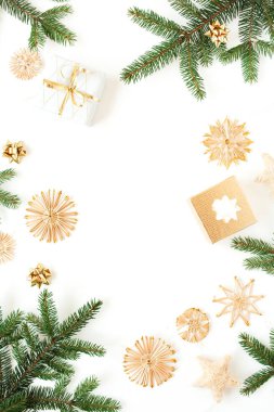 Noel / Yeni Yıl bayramı kompozisyonu. Köknar dallarının, hediye kutularının, beyaz arka planda saman süslerinin olduğu bir çerçeve. Düz yatış, üst görünüm şenlik modeli.