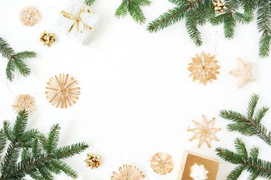 Noel / Yeni Yıl bayramı kompozisyonu. Köknar dallarının, hediye kutularının, beyaz arka planda saman süslerinin olduğu bir çerçeve. Düz yatış, üst görünüm şenlik modeli.