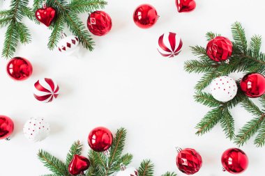 Noel / Yeni Yıl kompozisyonu. Çerçeveyi, köknar iğnesi dallarından, noel süslemelerinden ve beyaz arka plandaki süslemelerden oluşan boş fotokopi alanıyla düzenle. Düzlük, üst görünüm bayram konsepti.