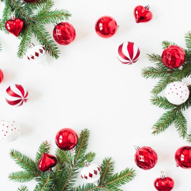 Christmas / New Year holiday composition. Mock up frame with blank copy space. Fir needle branches, Christmas baubles / balls, decorations on white background. Flat lay, top view festive concept.