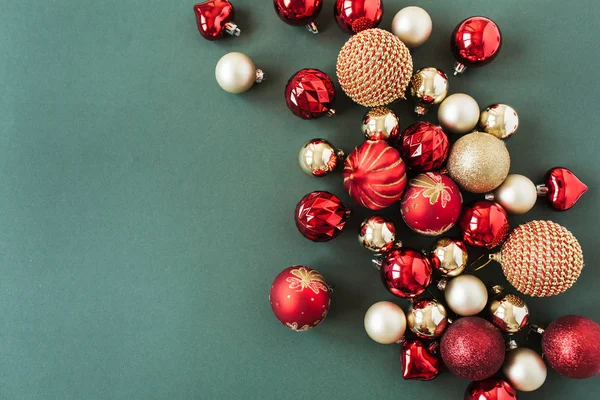 緑の背景に赤と金のクリスマスの泡 ボール フラットレイ トップビュー新年 クリスマスの休日の組成 — ストック写真