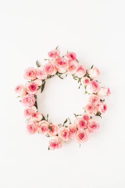Düz çerçeve kenarı, beyaz arkaplanda pembe gül tomurcuklarından yapılmış boş bir kopya alanı modeliyle. Üst görünüm çiçek kavramı.