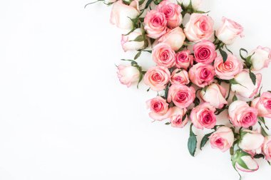 Beyaz arka planda pembe gül tomurcukları olan çiçek kompozisyonu. Düz yatış, üst görünüm.