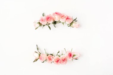 Düz çerçeve kenarı, beyaz arkaplanda pembe gül tomurcuklarından yapılmış boş bir kopya alanı modeliyle. Üst görünüm çiçek kavramı.