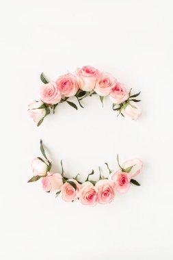 Beyaz arka planda pembe gül tomurcuklarının yuvarlak çerçeve sınırı. Boş fotokopi alanı oluştur. Düz konum, üst görünüm çiçek kompozisyonu.