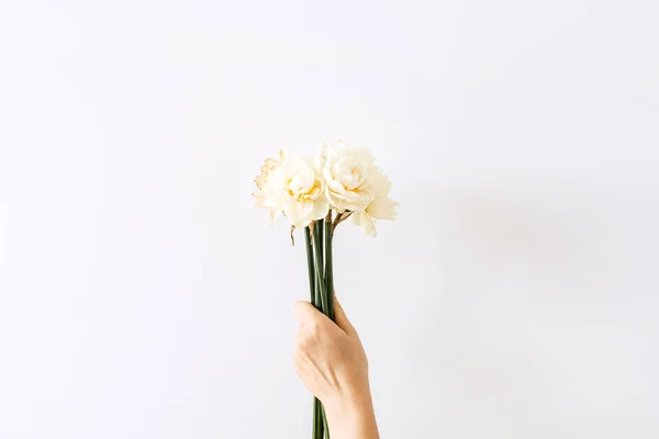 Mano Femenina Sostiene Ramo Flores Narcisas Sobre Fondo Blanco Puesta — Foto de Stock