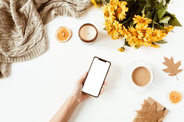 Kadınlar için ofis masası, içinde fotokopi alanı olan boş ekran telefon. Sarı papatya çiçekleri, süslemeler. Flat lay, top view girl boss blog iş konsepti sosyal medya, dergi, web sitesi.