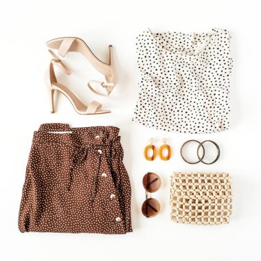 Beyaz arka planda kadın kıyafetleri ve aksesuarları olan moda kolajı. Puantiyeli etek, bluz, topuklu ayakkabı, çanta, güneş gözlüğü, küpeler, bilezik. Düzlük, üst görünüm moda blogu.