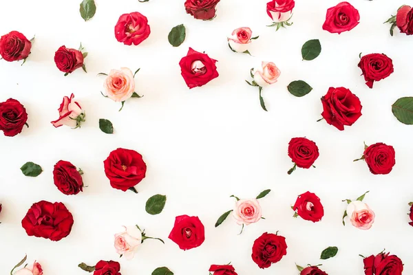 Flat lay frame border with blank copy space mockup made of pink and red rose flowers and leaves on white background. Top view floral concept.