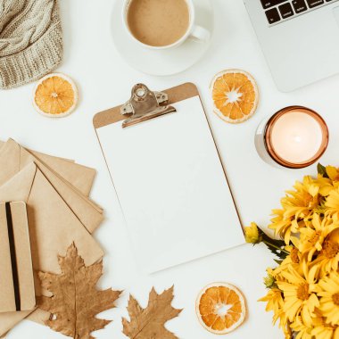 Sarı papatya çiçekleri buketi, kahve fincanı, portakal dilimleri ve ekoseyle süslenmiş ofis masası çalışma alanı. Düz konum, üst görünüm serbest iş konsepti sosyal medya, dergi.