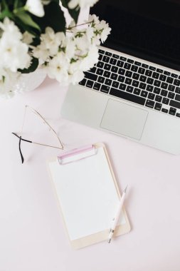 Ofis masası çalışma alanı, dizüstü bilgisayarı, çiçek buketi ve boş kağıt fotokopi masası. Düz, üst görünüm serbest meslek arkadaşı.