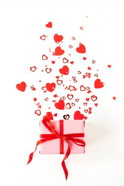 Sevgililer Günü kompozisyonu pembe hediye kutusu ve beyaz arka planda kalp sembolü konfetisi. Düz konum, üst görünüm tatil konsepti.